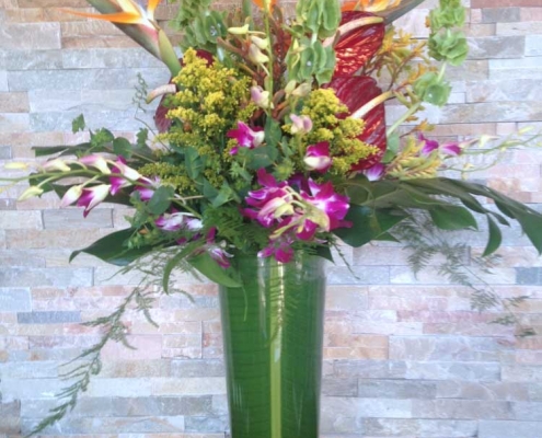 tropical arrangement in green vase